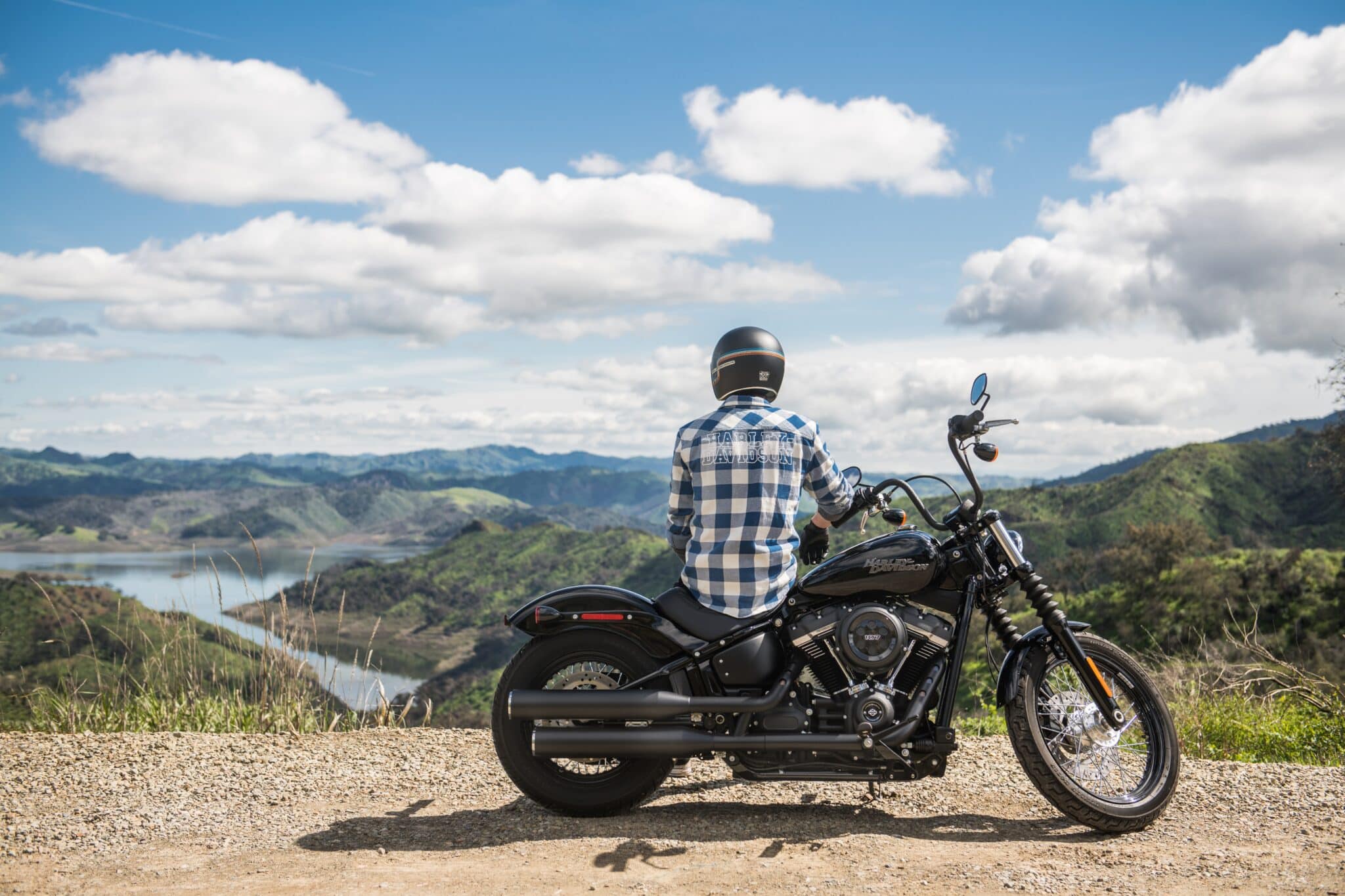Man sitting on his motorcycle looking out at a beautiful view of nature.