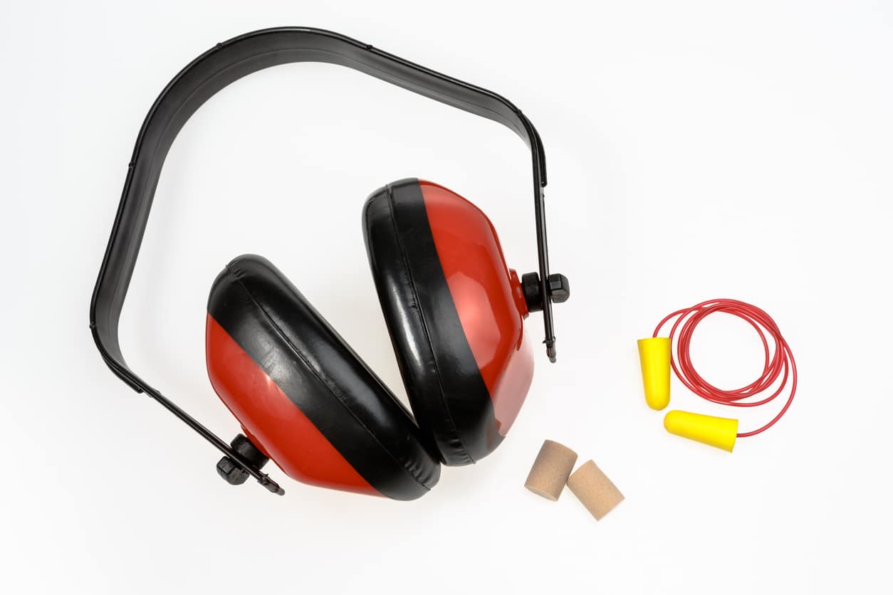 protective ear devices including earmuffs and earplugs on a white background