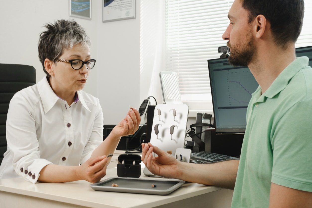 Audiologist discusses hearing aid care with patient
